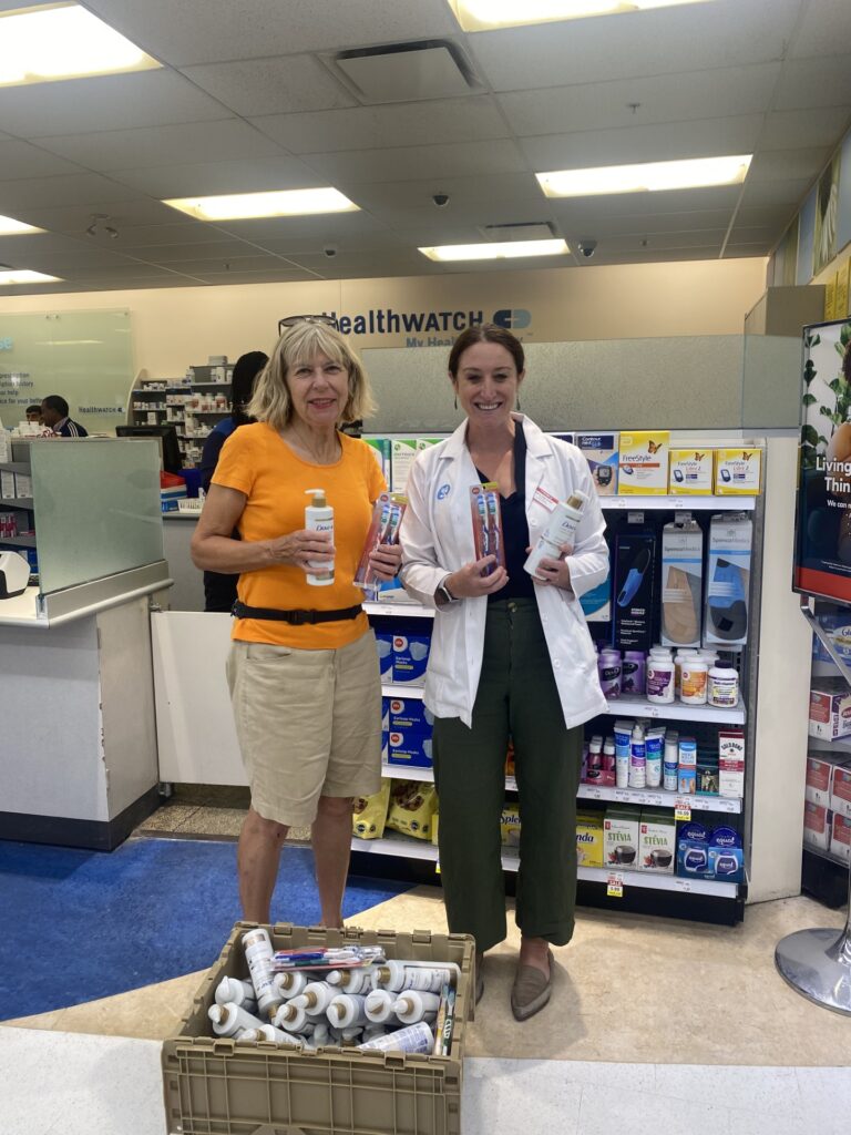A photo of Councillor Kavanagh with a pharmacist, holding the donations for the Cornerstone Women's Shelter. 